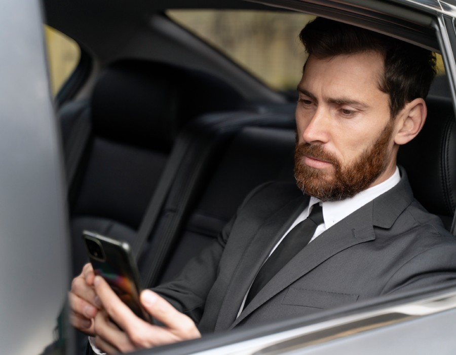 Client VTC en costume utilisant son téléphone